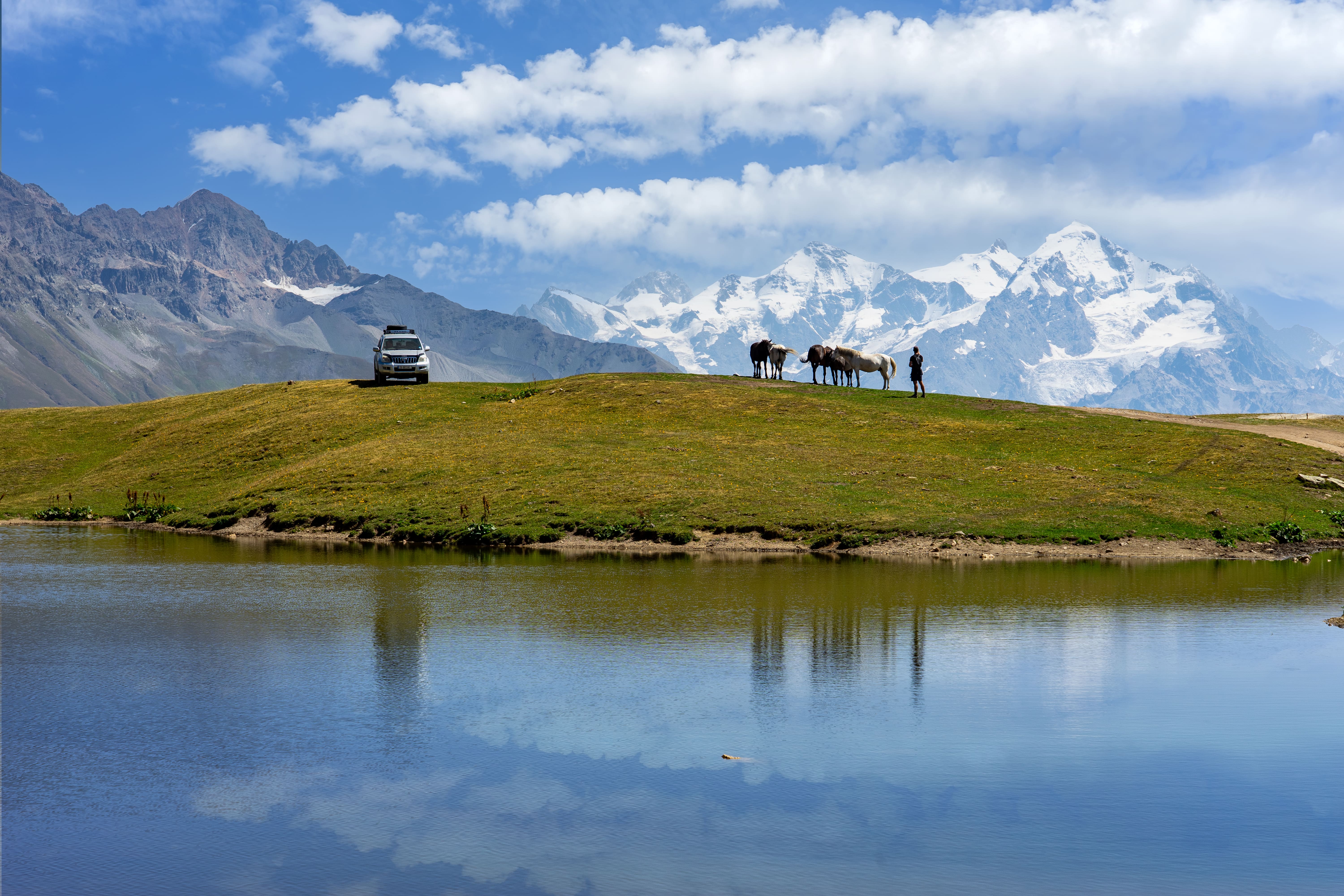 Hikers trekking through majestic Caucasus mountains in Svaneti region with ancient stone towers